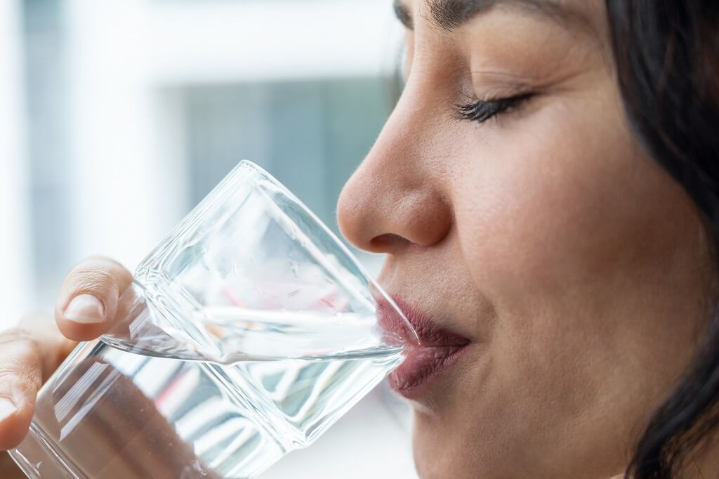 Osoba pije vodu kao važan deo pravilnog unosa vlakana i hidratacije